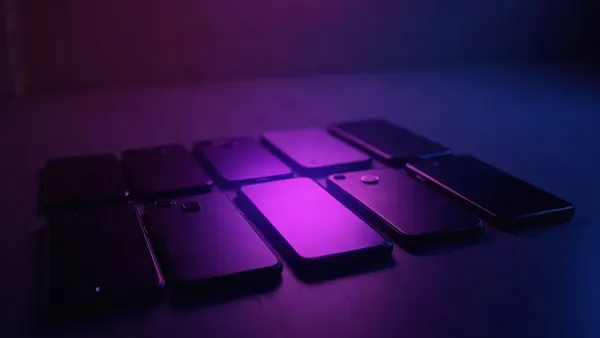 Several smartphones lined up, a purple spotlight on the middle one (article illustration)